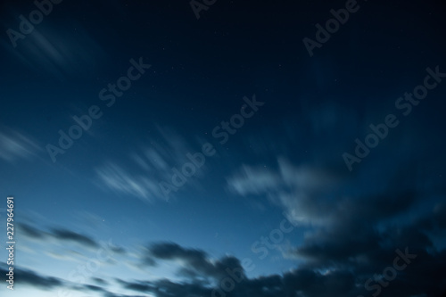 Beautiful blue dawn in the Alps mountains with clouds and stars