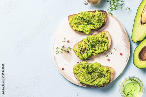 Healthy breakfast, avocado toasts on cutting board. Top view, space for text.