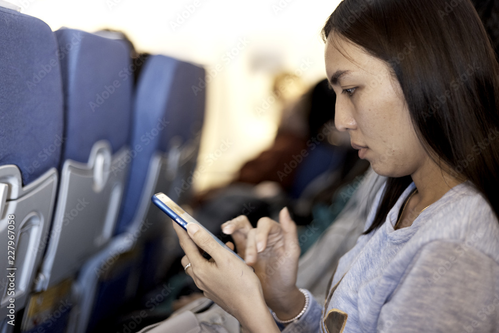 woman using smartphone airplane