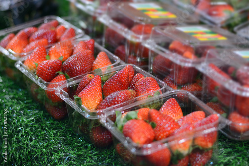 strawberry fruit in package for sale at market as background