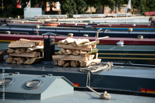 pile of freshly chopped wood on roof of narrowboat in England in perparation for winter