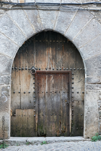 Ancient dark wood entrance door of a stone house