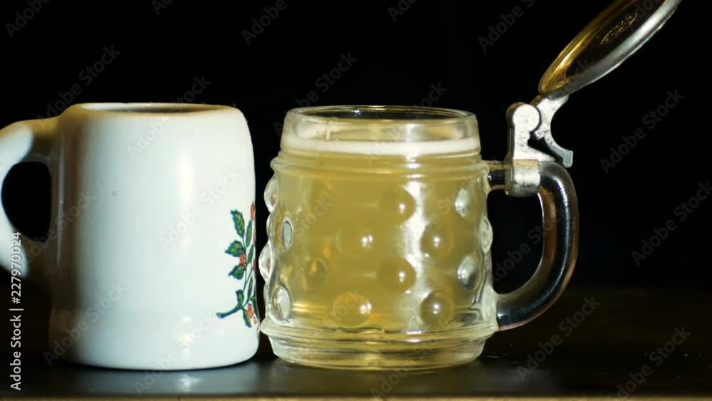 representation of alcohol abuse, hands toasting with small mugs full of beer representation of alcohol abuse, hands toasting with small mugs full of beer