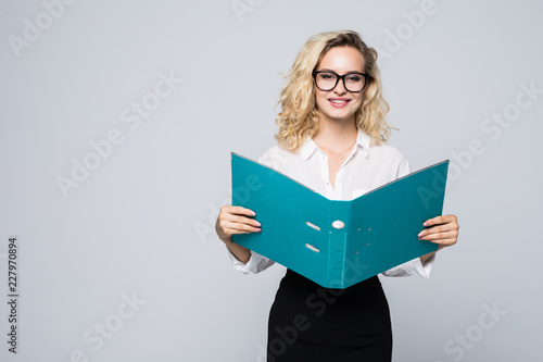 Smiling bussiness woman reading contracts from a folder isolated on white background
