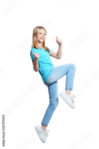 Cute girl in casual clothing showing thumbs up on white background