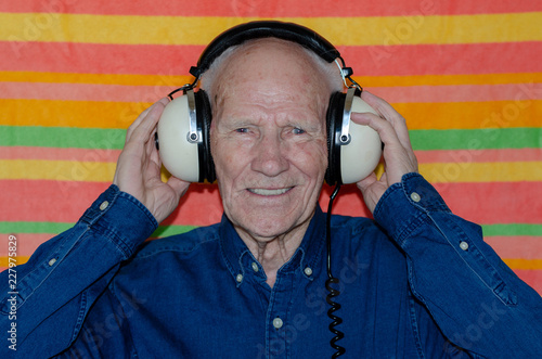 old man listening to music with headphones photo