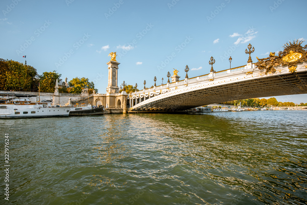 View on the riverside with Alexandre bridge from the boat sailing on Seine river during the sunset in Paris