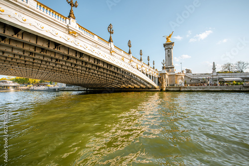 View on the riverside with Alexandre bridge from the boat sailing on Seine river during the sunset in Paris photo