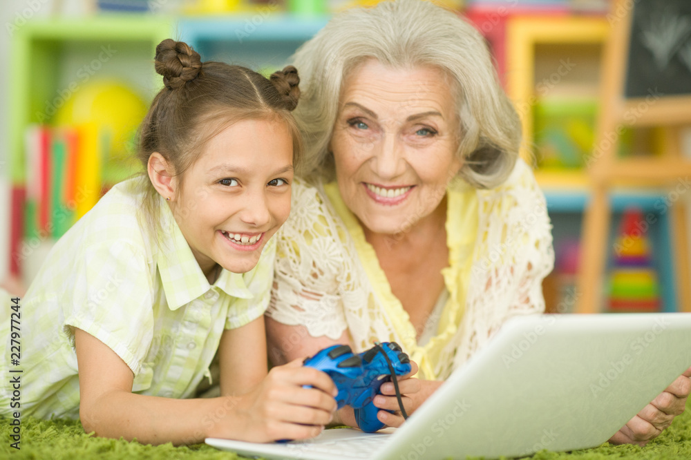 Portrait of a grandmother and daughter playing computer game Portrait of a grandmother and daughter playing computer game