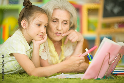 Portrait of a grandmother with little girl doing homework