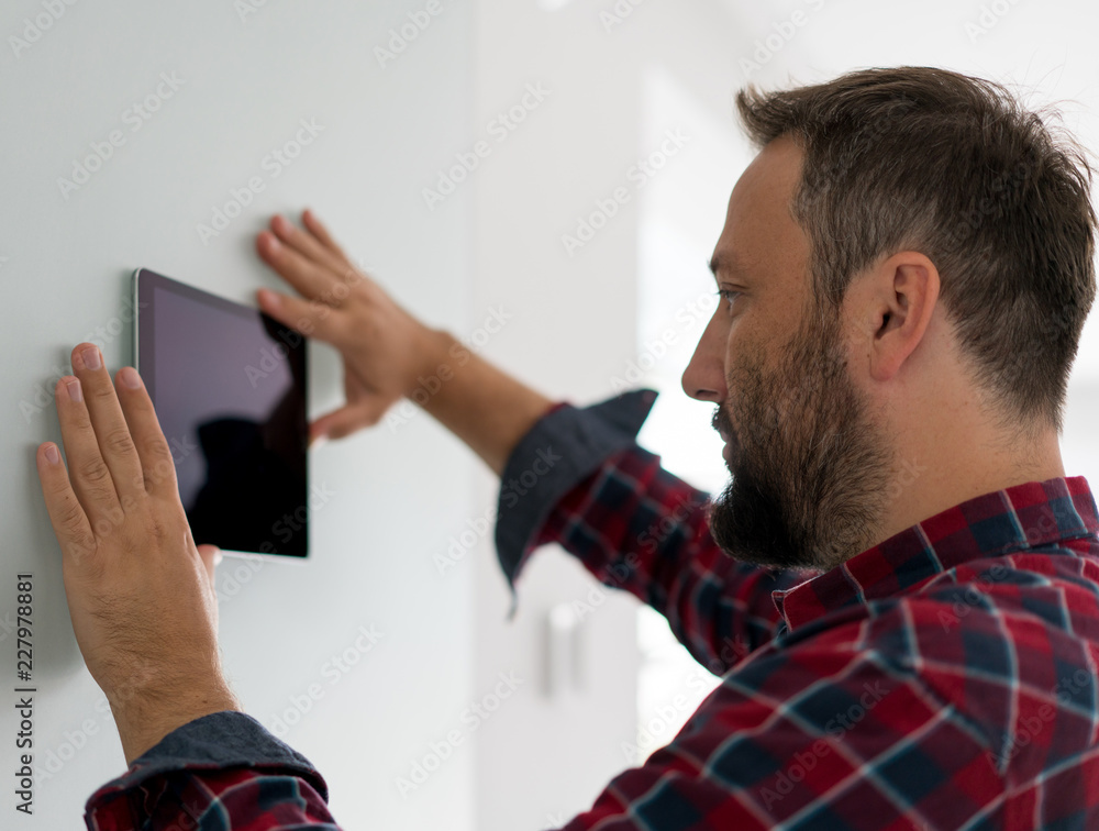 Fototapeta premium Man using smart home device