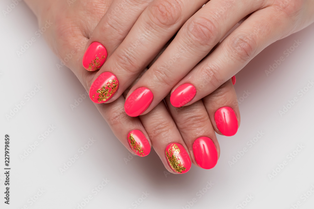 Summer Red, coral manicure with gold foil on short oval nails on a white background close-up
Summer Red, coral manicure with gold foil on short oval nails on a white background close-up