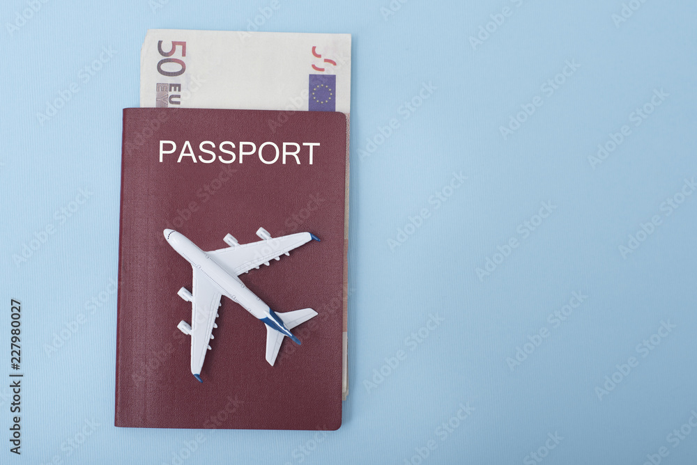 Fototapeta premium Airplane on the cover of the passport. Euro. Travel concept. Blue background