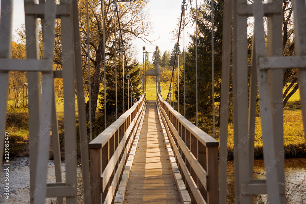 Suspension bridge on a rope on the background of the autumn landscape. Suspension bridge on a rope on the background of the autumn landscape.