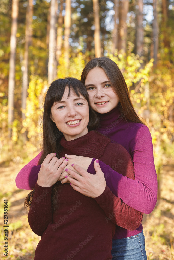 Cute portrait of mother and daughter in the autumn forest. Cute portrait of mother and daughter in the autumn forest.