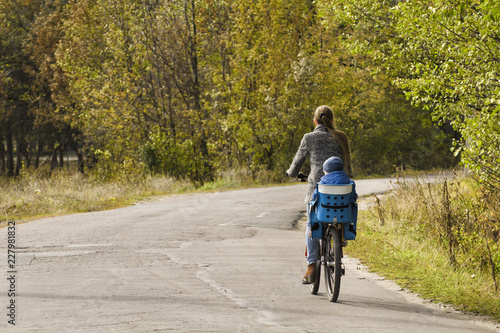 Wallpaper Mural Mom and son are riding a bicycle on the autumn road. Back view. Torontodigital.ca
