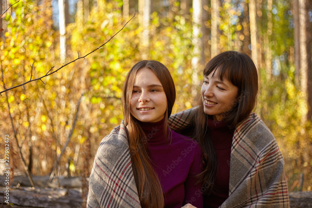 Cute portrait of mother and daughter in the autumn forest. Cute portrait of mother and daughter in the autumn forest.