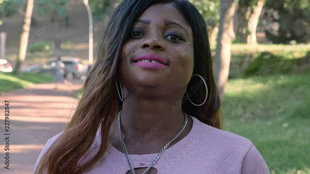 Smiling pretty young african woman loking at camera walking- slow motion Smiling pretty young african woman loking at camera walking- slow motion