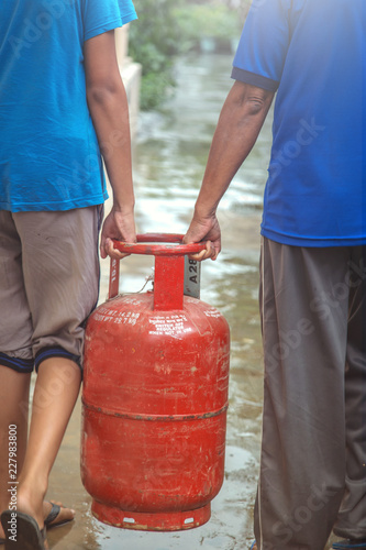 Photography Two men carrying lpg from filling station back to their home