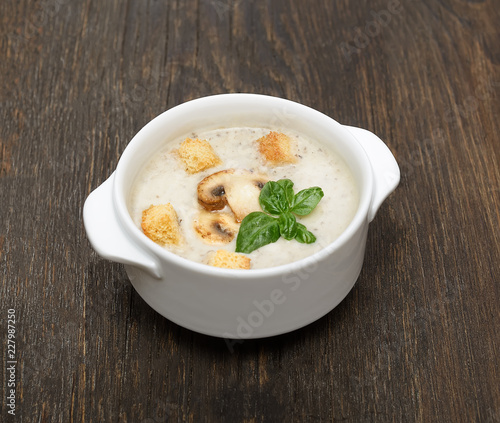 champignon soup with crackers on wooden background