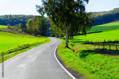 Eine kurvige, freie Landstraße in einer hügeligen Landschaft in Nordrhein-Westfalen.