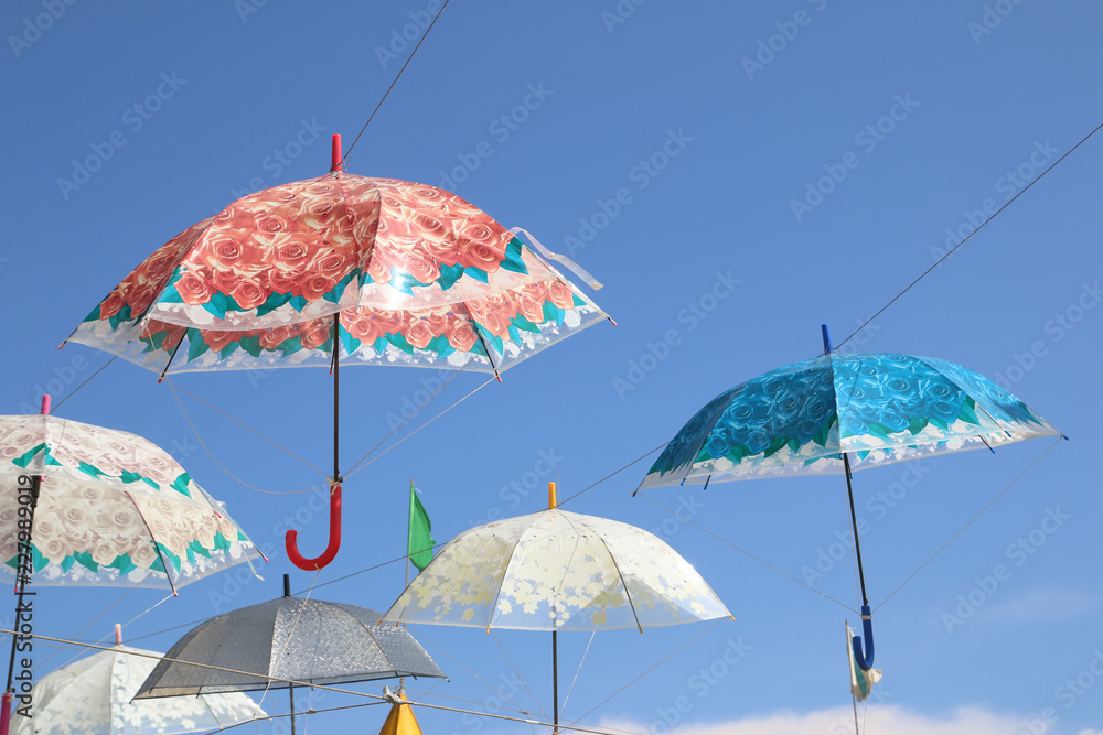 floreados paraguas abiertos de colores en un cielo azul de verano para dar sombra en un mercadillo