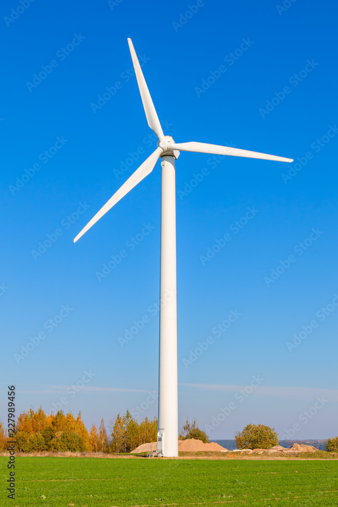 Wind turbine among a green field on a sunny autumn day Wind turbine among a green field on a sunny autumn day