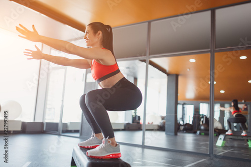 Woman doing squats on step platform
