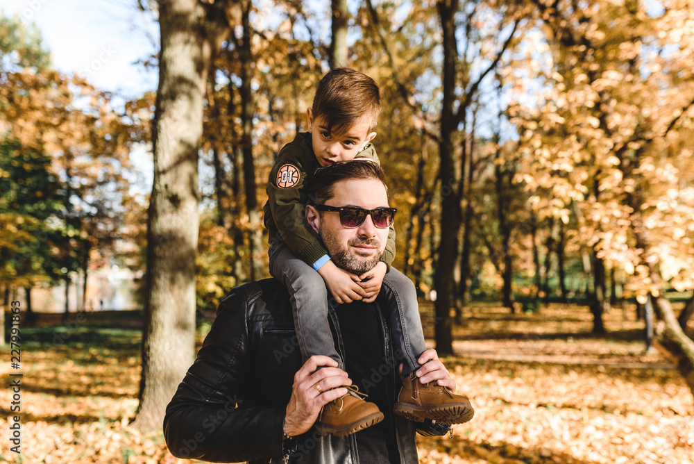father and son in autumn park father and son in autumn park