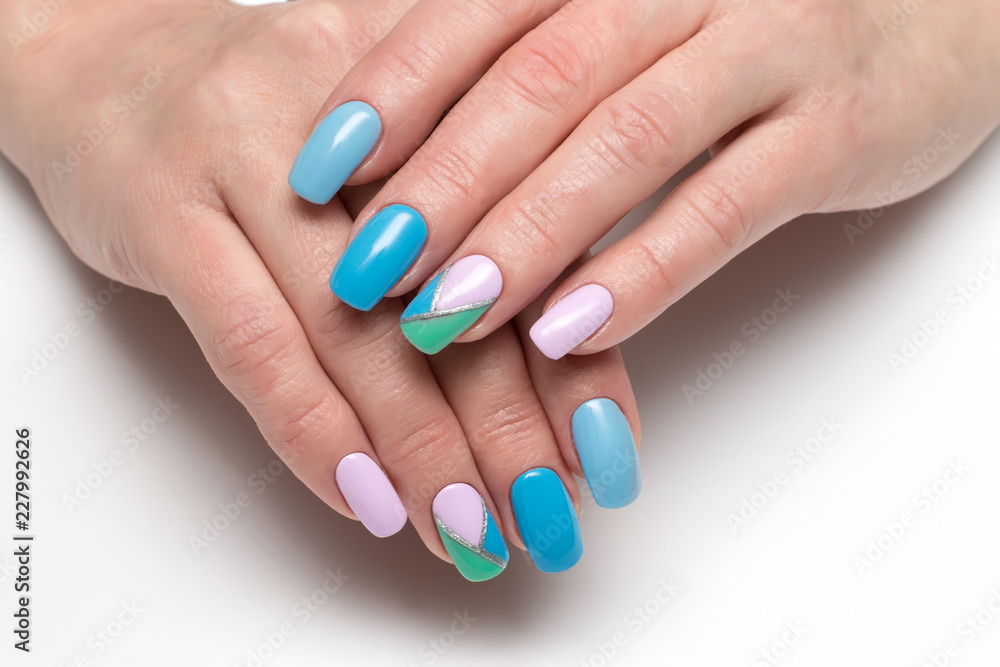 blue, green, lilac color manicure with rhombuses and a silver stripe on long square nails on a white background close-up
blue, green, lilac color manicure with rhombuses and a silver stripe on long square nails on a white background close-up