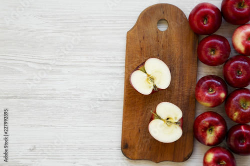 Raw red apples on white wooden background, overhead view. Flat lay, from above, top view. Blank space.