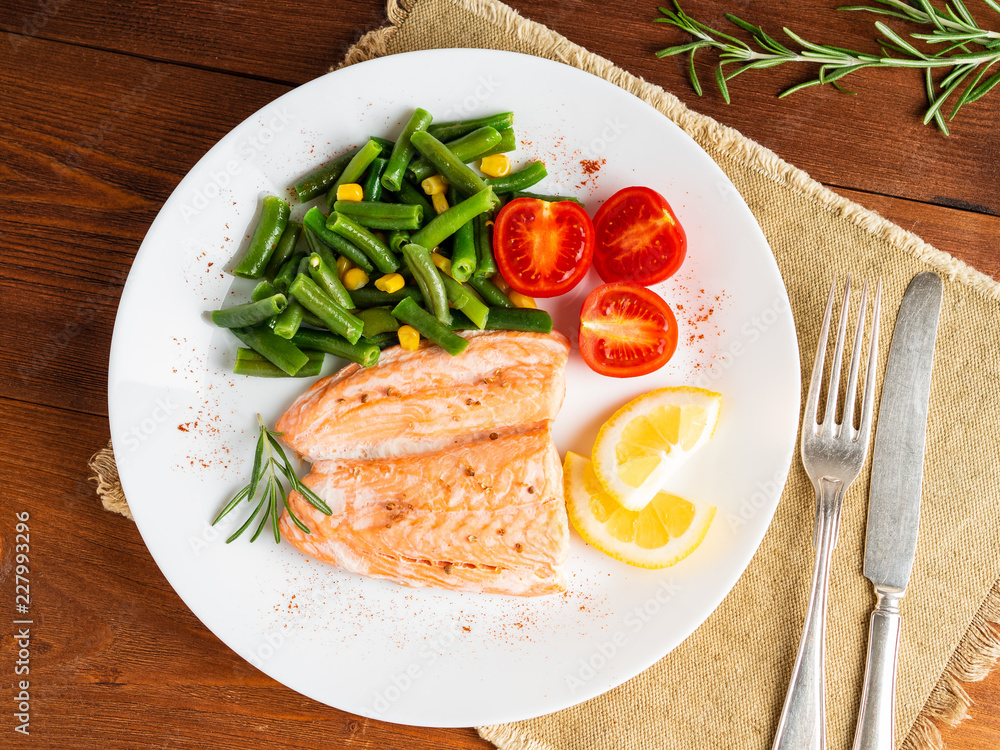 Fish salmon steamed with vegetables. Healthy diet food, dark wooden backdrop, top view, close-up Fish salmon steamed with vegetables. Healthy diet food, dark wooden backdrop, top view, close-up