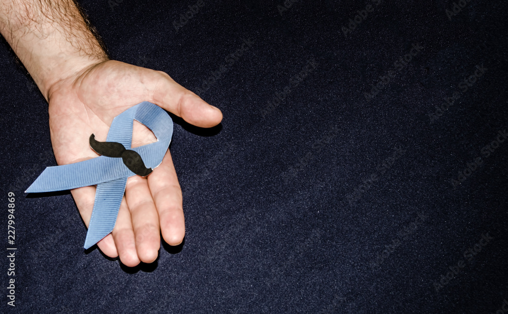 Man holding a blue ribbon, blue november concept Man holding a blue ribbon, blue november concept