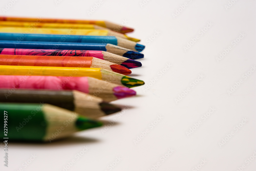 Fototapeta premium set of colored pencils lying on the notebook. White background. Isolate. Christmas colors
