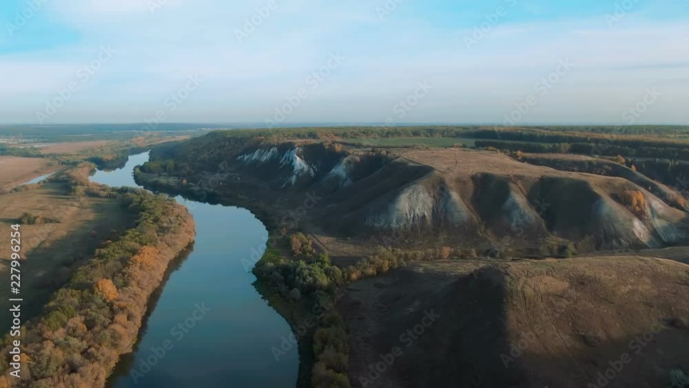 Cinematic 4k aerial view. Flying over green grassy rocky chalk hills, mountains and a river Cinematic 4k aerial view. Flying over green grassy rocky chalk hills, mountains and a river