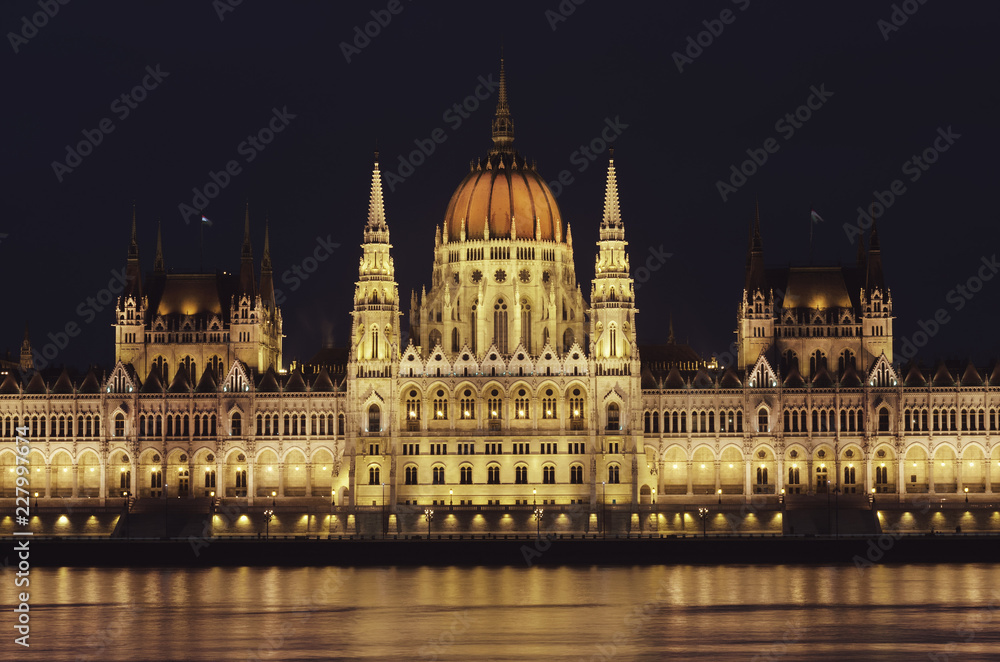 Night view of the illuminated building of the hungarian parliament in Budapest. A beautiful reflection of the parliament building on the Danube River. Winter city night landscape.