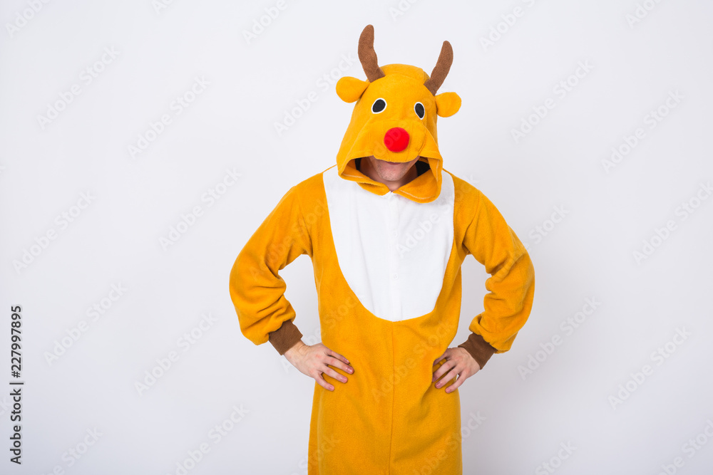 Obraz premium Holiday, Christmas and people concept - Man in Santa Claus deer costume standing on white background