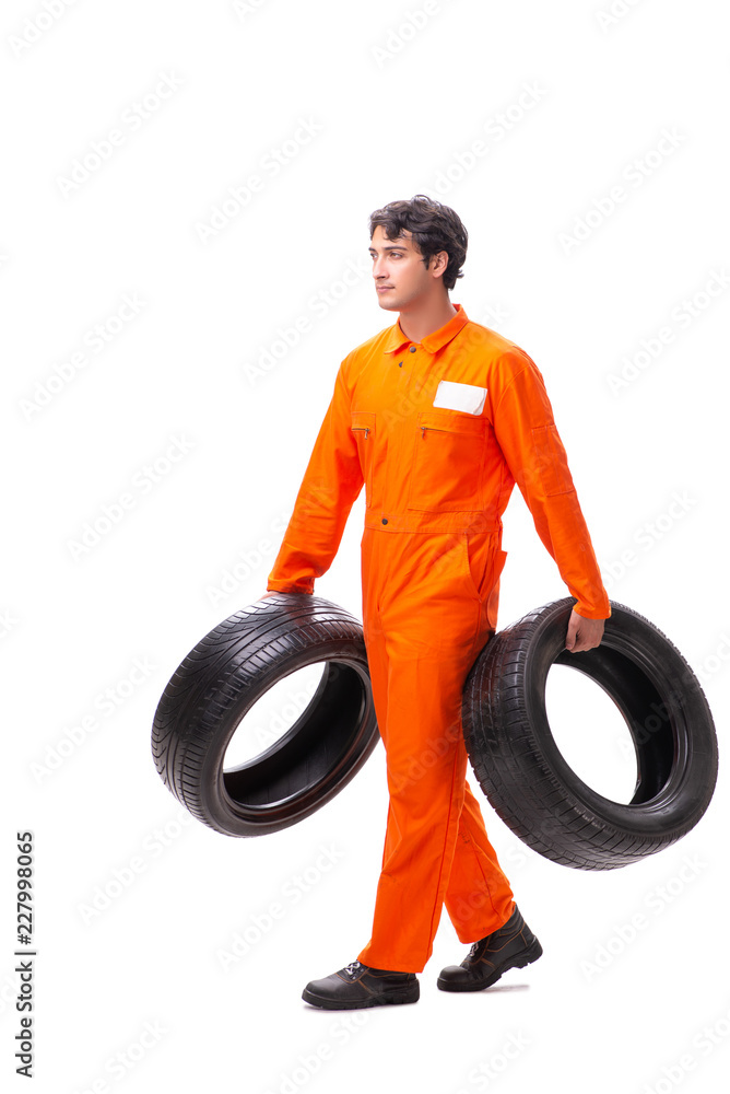 Young garage worker with tyre isolated on white Young garage worker with tyre isolated on white