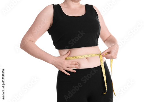 Overweight woman measuring waist before weight loss on white background