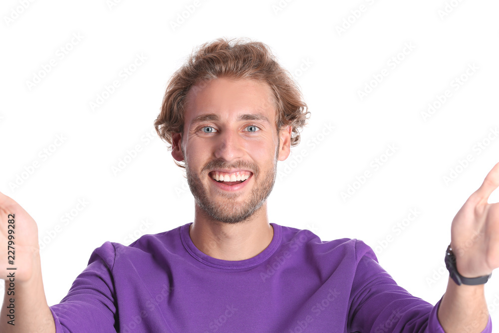 Handsome young man laughing and taking selfie on color background Handsome young man laughing and taking selfie on color background