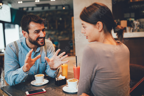 Young happy couple at a date in a coffee shop