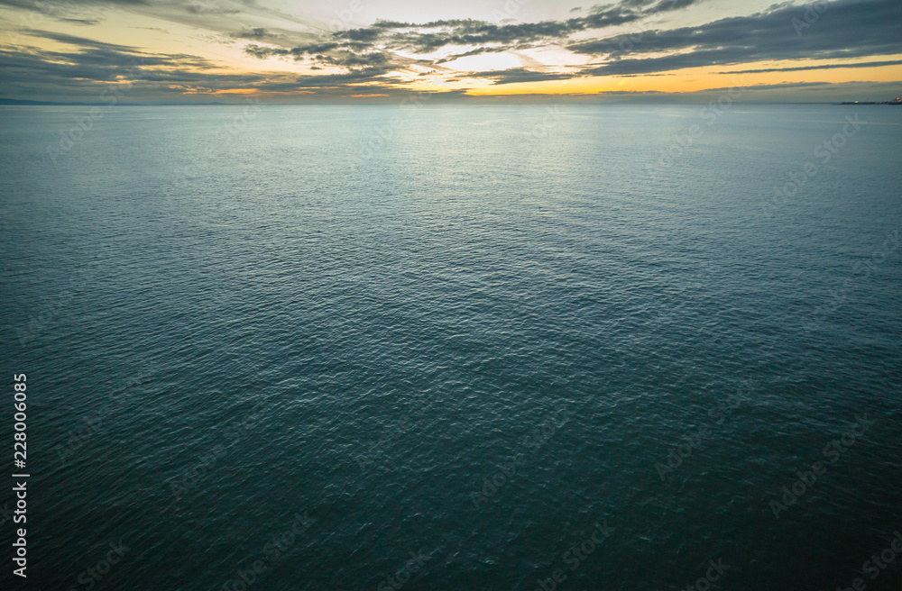 Horizon and ocean blending together at sunset time on a cloudy day