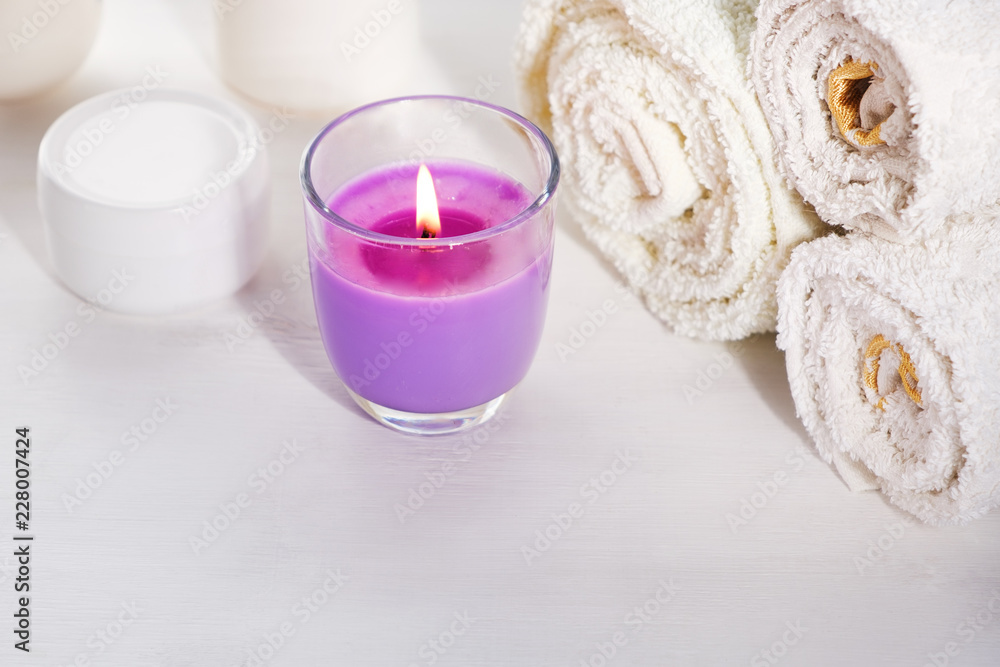 White towels scented candle with lavender scent cream jar on white background for cosmetic procedures White towels scented candle with lavender scent cream jar on white background for cosmetic procedures