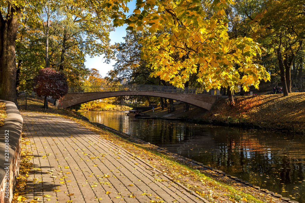 Sunny autumnal day in central public park of Riga - capital of Latvia and a major commercial, cultural, historical and financial center of the Baltic region Sunny autumnal day in central public park of Riga - capital of Latvia and a major commercial, cultural, historical and financial center of the Baltic region