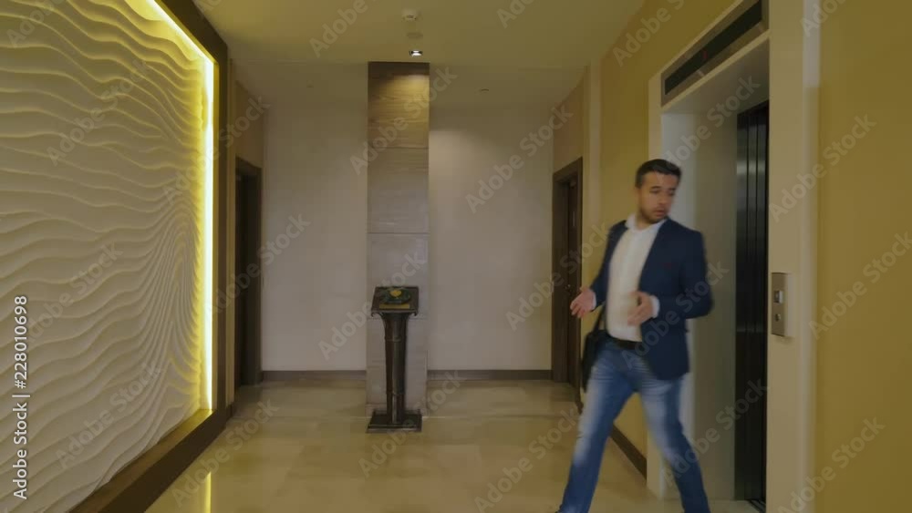 Two business men coming out elevator and walking on long hall in business hotel Two business men coming out elevator and walking on long hall in business hotel