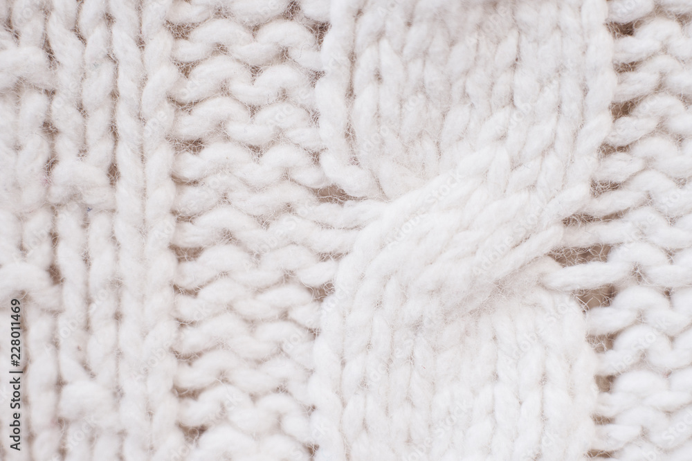 Knit texture of white wool knitted fabric with cable pattern as background Knit texture of white wool knitted fabric with cable pattern as background