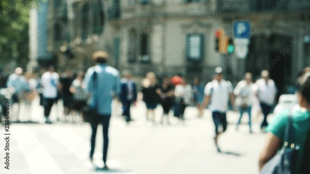 Rear view of people - slow motion defocused view city atmosphere with adults and seniors people crossing busy intersection in central Barcelona crossroads passage slowmotion Rear view of people - slow motion defocused view city atmosphere with adults and seniors people crossing busy intersection in central Barcelona crossroads passage slowmotion