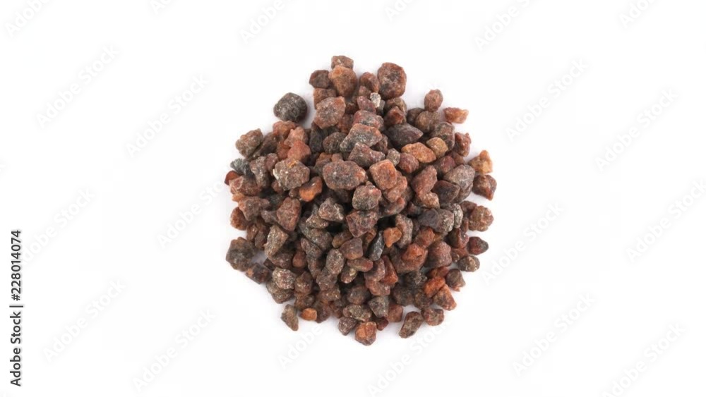 Top view from above of a brown kala namak salt crystals pile. Rotating on the turntable. Isolated on the white background. Close up. Macro. Top view from above of a brown kala namak salt crystals pile. Rotating on the turntable. Isolated on the white background. Close up. Macro.