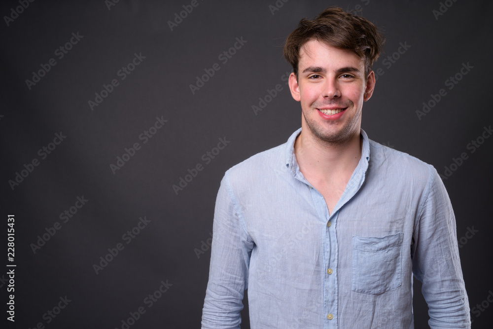 Studio shot of young handsome man against gray background Studio shot of young handsome man against gray background