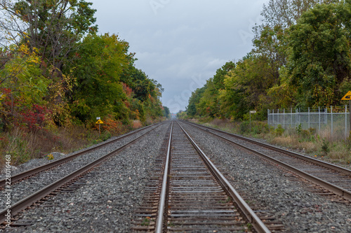 Mississauga, CANADA - October 15, 2018: Urban Train tracks edged by trees leading off into the distance